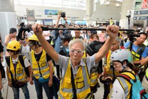 香港デモ、高齢者が警察本部前で座り込み 若者への暴力を批判